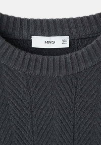 Suéter de punto gris oscuro con cuello acanalado y patrón de espiga. La etiqueta muestra las tallas: EUR M, USA M, MEX M. Textura suave.