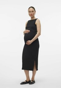 Musthave mustririga rasedate kleit, millel on särgideta disain, külje lõhed, põlvepikkus, valmistatud siledast kangast, kantud inimesel, kelle käed on kõhul.