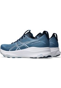Scarpe sportive blu con tomaia testurizzata, accenti argento e un'ammortizzazione bianca. Presentano un tallone strutturato e una suola nera flessibile.