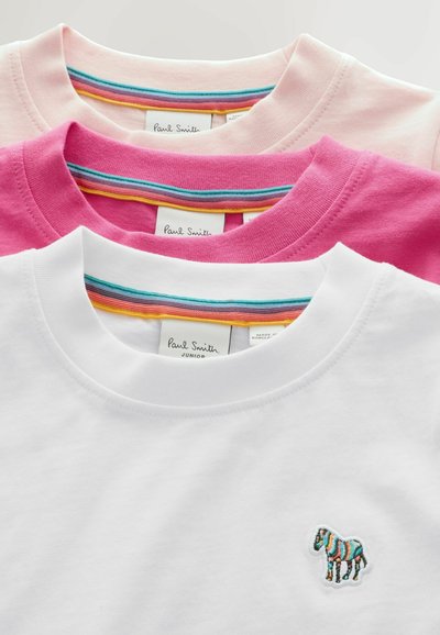 Tre t-shirt a girocollo piegate nei colori bianco, rosa e rosa chiaro con colli interni a righe arcobaleno e una piccola toppa di zebra multicolore sulla maglietta bianca.