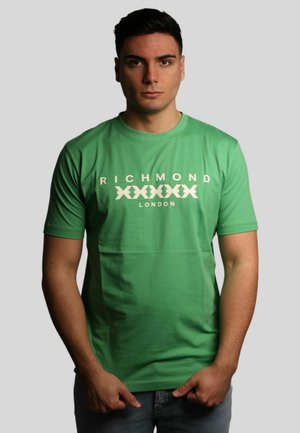 T-shirt in cotone verde con il testo "RICHMOND" e "LONDON" in bianco, accompagnato da una grafica di un pesce. Collo giro e maniche corte.