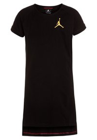 Czarna bawełniana sukienka z krótkimi rękawami, z złotym logiem Jumpman na piersi i czerwonym akcentem wzdłuż dołu.