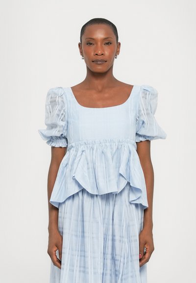 Abito azzurro chiaro con scollo quadrato, maniche corte a palloncino e design peplum. Il tessuto presenta un leggero motivo a quadri e una consistenza morbida.