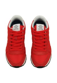 Sneakers rossi realizzati con una combinazione di materiali in rete e camoscio, con lacci piatti e una suola bianca, con un'etichetta che recita "CORRI PIÙ VELOCE DI QUANTO PUOI."