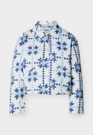 Veste blanche matelassée avec boutons-pression, présentant des motifs de patchwork en formes d'étoiles bleues et de diamants, avec un col.