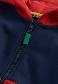 Kapuzenshirt mit dunkelblauem Körper und roter Kapuze, schwarzem Reißverschluss und grünem Stoff-Zugband. Angenehme Textur und modernes Design.