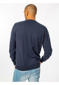 Suéter azul marino de manga larga, con puños y dobladillo acanalados, que presenta un clásico cuello redondo y una textura suave y lisa.