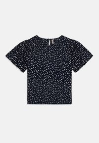 Blouse bleu marine, manches courtes à volants, motif à pois blancs éparpillés, col rond, tissu léger, design minimaliste.