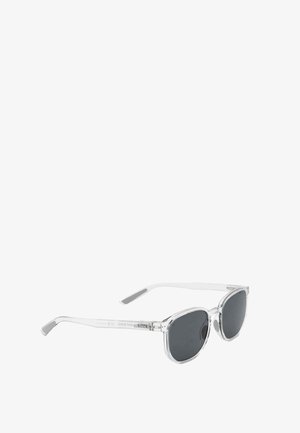 Gafas de sol con montura transparente, lentes rectangulares oscuras y bordes ligeramente redondeados vistas en ángulo sobre un fondo blanco.