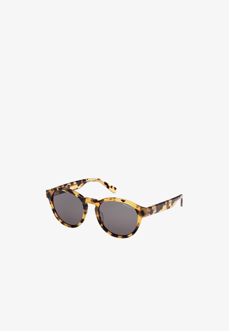 Kilpikonnakuosiset aurinkolasit pyöreillä kehillä, tummanharmailla linsseillä ja kiiltävällä pinnalla. Sangan osissa on hienovaraista brändäystä ja kuvioitu muotoilu.