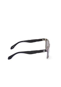 Occhiali da sole con montatura leggera di colore scuro, lenti sfumate viola e aste in gomma nera testurizzata con il logo Adidas.