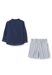 Camisa de manga larga azul marino con detalles de botones y pantalones cortos rayados en azul claro y blanco. Ambos artículos tienen un ajuste relajado y un diseño casual.