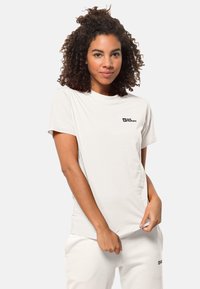 Weißes Baumwoll-T-Shirt mit Rundhalsausschnitt, kurzen Ärmeln und einem kleinen schwarzen Logo auf der linken Brustseite. Glatte Textur, lässige Passform.