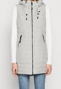 Grey sleeveless vest with a hood, front zipper, black accents, side pockets, and a quilted texture. Worn over a white long-sleeve shirt.