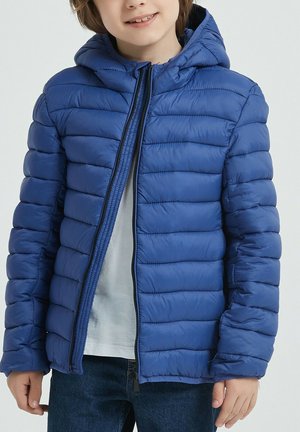 Veste matelassée bleue avec des lignes horizontales, capuche, fermeture éclair avant et poignets élastiques. Confectionnée dans un tissu lisse et léger.