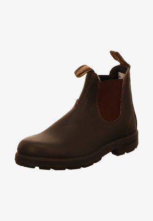 Bottine en cuir marron avec panneaux latéraux élastiques, tirettes et semelle en caoutchouc texturée. Fini lisse avec des détails de surpiqûre contrastants.