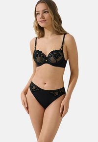 Zwart lingeriesetje met een onderwired bh met kantafwerking en bijpassende hoge taille slips, beiden met bloemmotieven en gladde stof.