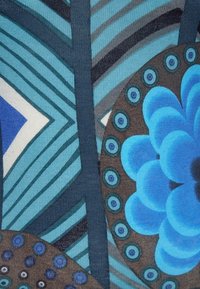 Textil mit blauen Blumen- und Kreis-Mustern in Schattierungen von Türkis, Braun und Grau. Geometrische Linien und Akzente schaffen visuelles Interesse.