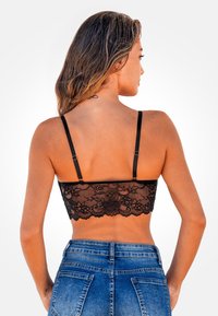 Bralette negro de encaje con tirantes ajustables, con patrones florales a lo largo del dobladillo, textura suave y diseño ceñido.