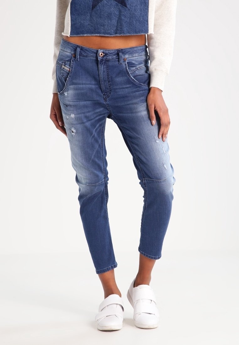 Jeans i medium blått med slitna detaljer och en tapered passform. Har en standard midja och femficksdesign.