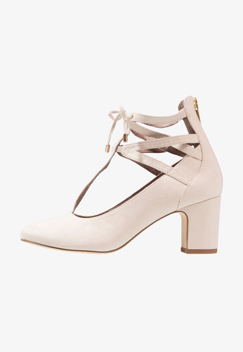 Décolleté in suede beige con punta affusolata, design a taglio, lacci regolabili nella parte anteriore e tacco a blocco di 6,5 cm con dettagli in zip dorata.