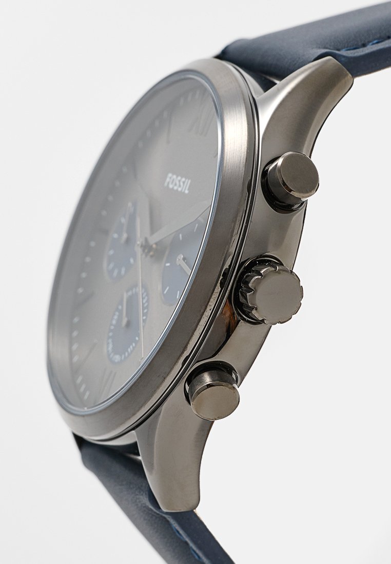 Montre Fossil pour hommes avec un cadran gris, un boîtier en acier inoxydable argenté, trois sous-cadrans et un bracelet en cuir bleu avec des accents en relief.