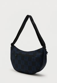 Črno-modra karo torbica za ramo z žepom spredaj z zadrgo, nastavljivim trakom in vzorcem logotipa Lacoste.