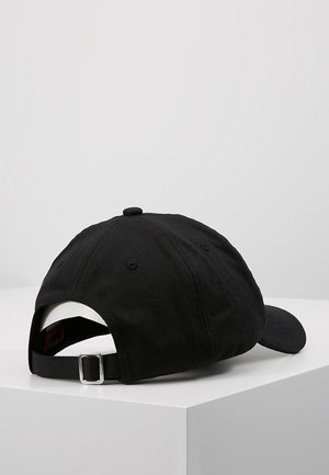 Czarna regulowana czapka z daszkiem z metalową klamrą, przeszywanymi otworami wentylacyjnymi i guzikiem na górze, umieszczona na białej powierzchni.