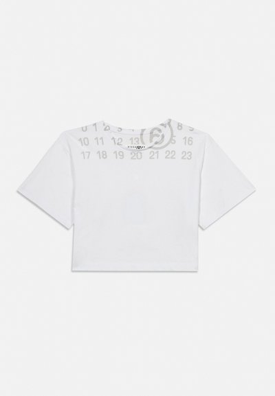 Fehér, rövid ujjú, kivágott póló kerek nyakkivágással, szürke világos háttéren, hátulnézetben elhelyezve.