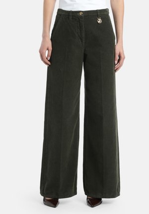 Pantalons en velours côtelé à jambes larges de couleur vert foncé avec des côtes verticales. Détail d'un bouton doré et d'un charme à la taille. Tissu texturé.