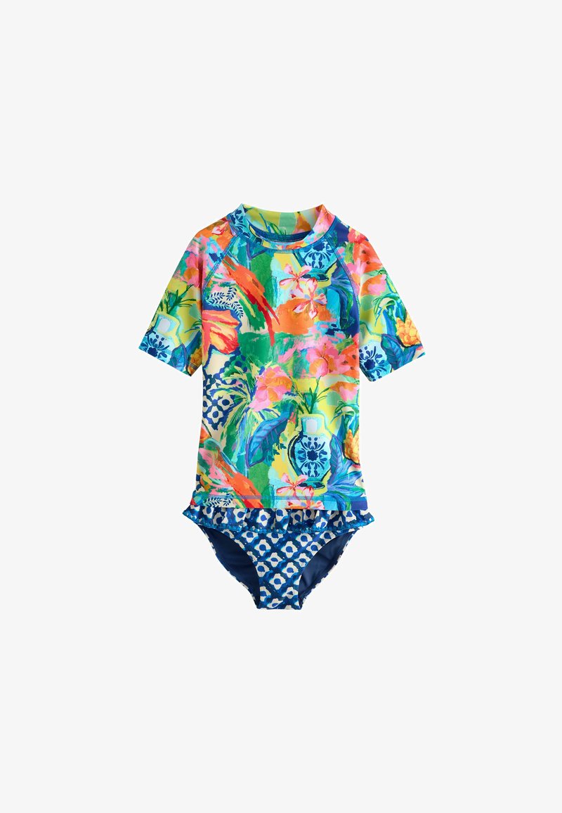 Maillot de bain coloré à manches courtes avec motifs floraux et vase, bas à motifs géométriques bleu et blanc avec bordure à volants.