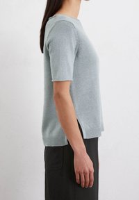 Lyseblå strikket sweater med korte sleeves, ribbet kant, sideslids og rund hals. Blød tekstur og afslappet design.