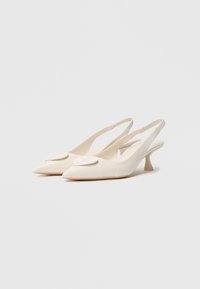 Sapatos de salto slingback em material texturizado off-white, bico fino, com um destaque de folha e salto baixo e curvado.