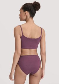 Bessenkleurige katoenen bralette met bijpassend high-rise ondergoed. Eenvoudig ontwerp met dunne bandjes en een gladde textuur, bekeken vanaf de achterkant.