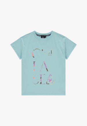 Camiseta de manga corta azul claro con letras multicolores y parcialmente camufladas que forman la frase "C'OESI LA SEA" en el frente.