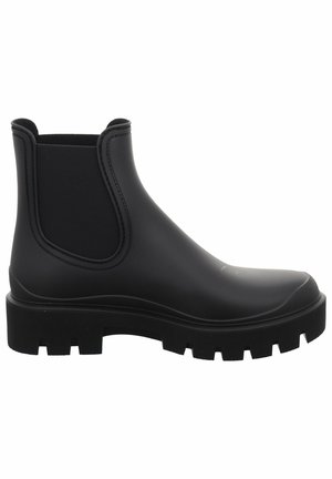 Zwarte rubberen Chelsea-boots met elastische zijpanelen en een chunky, gestructureerde zool. Gladde afwerking zonder zichtbare hardware of patronen.