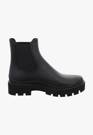 Botas Chelsea negras de goma con paneles laterales elásticos y una suela gruesa y texturizada. Acabado liso sin herrajes o patrones visibles.