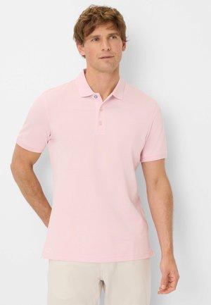 Polo rose clair, à manches courtes, en tissu doux. Équipé d'un col avec des boutons et d'un logo discret sur la poitrine.