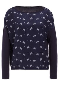 Maglietta a maniche lunghe blu navy con un motivo a fiocchi bianchi sparsi. Tessuto morbido con una vestibilità comoda e un ampio scollo, adatta per un abbigliamento informale.
