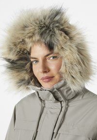 Light gray jacket featuring a large faux fur hood in beige and brown tones, with a high collar and adjustable drawstrings.