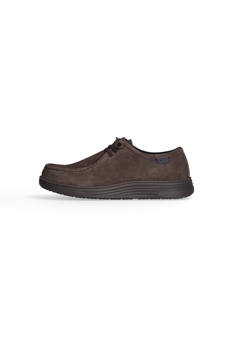 Scarpe stringate in suede marrone con punta rotonda, suola in gomma a profilo basso e logo discreto sul lato. Texture liscia con dettagli di cucitura.