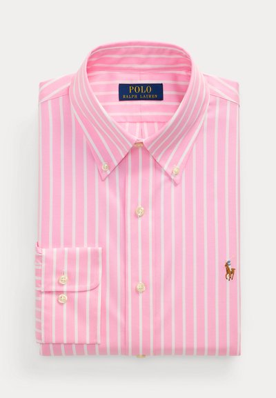 Ροζ ανοιχτό πουκάμισο με μακριά μανίκια και λευκές ρίγες, γιακά με κουμπιά και μικρό κεντημένο λογότυπο παίκτη πόλο. Τακτοποιημένο διπλωμένο.