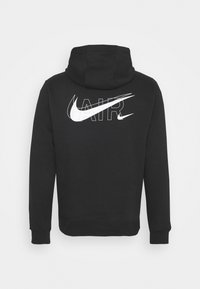 Černá mikina s kapucí z měkké tkaniny, s velkým bílým logem Nike swoosh a textem "AIR" na zádech. Navržena s klokaní kapsou a kapucí.