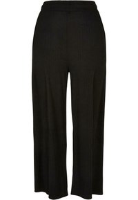 Pantalon large noir côtelé avec une ceinture élastique. Le tissu a une finition texturée, améliorant le confort et la liberté de mouvement.
