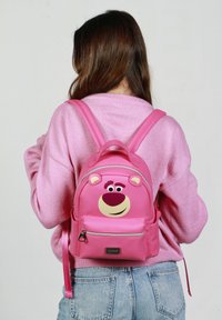Mochila rosa con diseño de cara de oso, con orejas grandes, cierre con cremallera y correas ajustables. Hecha de material sintético suave.