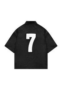 Chemise noire à manches courtes avec col pointu et grand numéro blanc 7 centré dans le dos.
