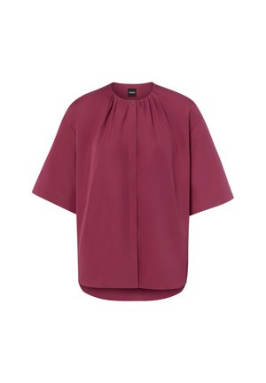 Kurzärmelige, locker sitzende Bluse in tiefem Mauve mit rundem Ausschnitt und plissierten Details nahe dem Kragen, Knopfverschluss am Hals.