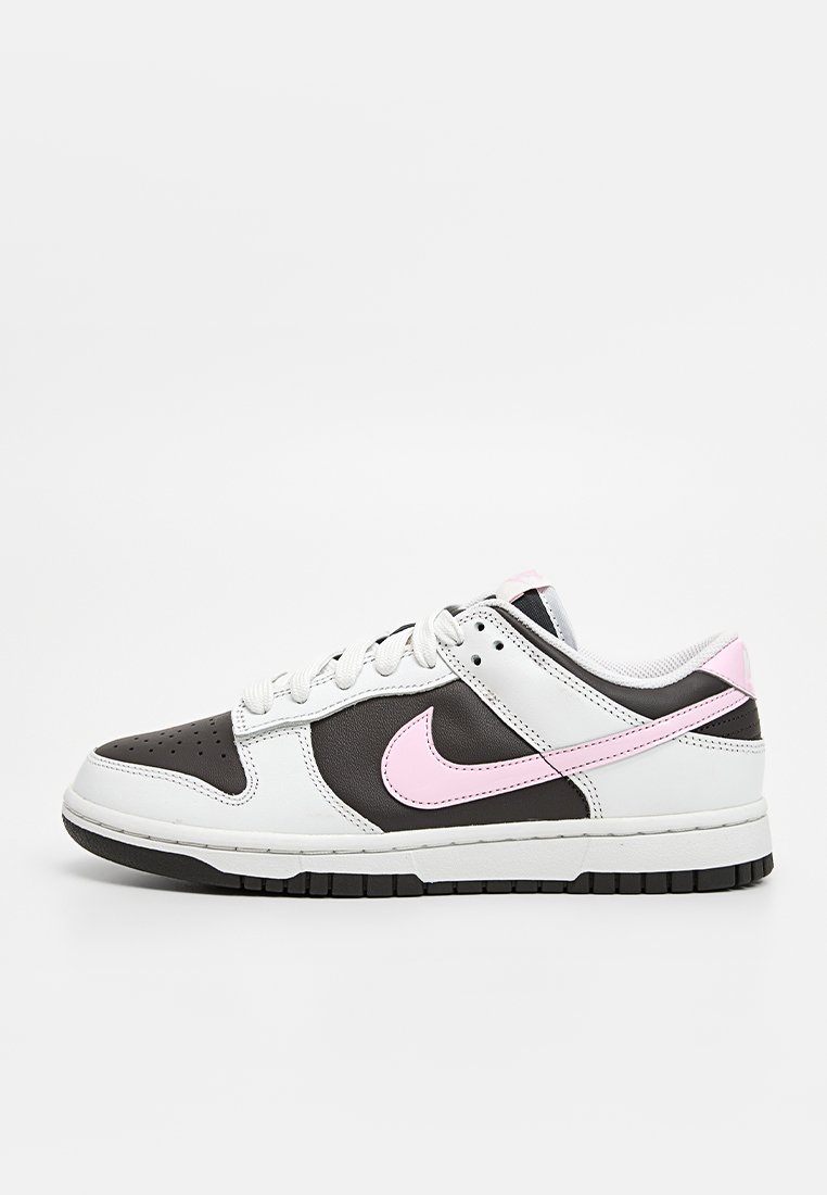 Nike-Sneaker mit einem Obermaterial aus weißem Leder, schwarzen Lederakzenten, pinkem Logo, Perforationen an der Zehe und einer schwarzen Gummisohle.