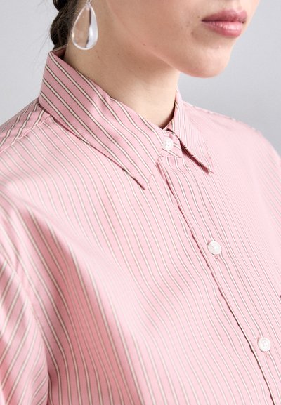 Light pink striped shirt with a button-down collar, featuring a smooth texture and white buttons, partially visible in the image.
