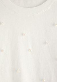 Hvid T-shirt med korteærmer lavet af blødt stof med en glat tekstur, prydet med spredte falske perler for ekstra detalje.